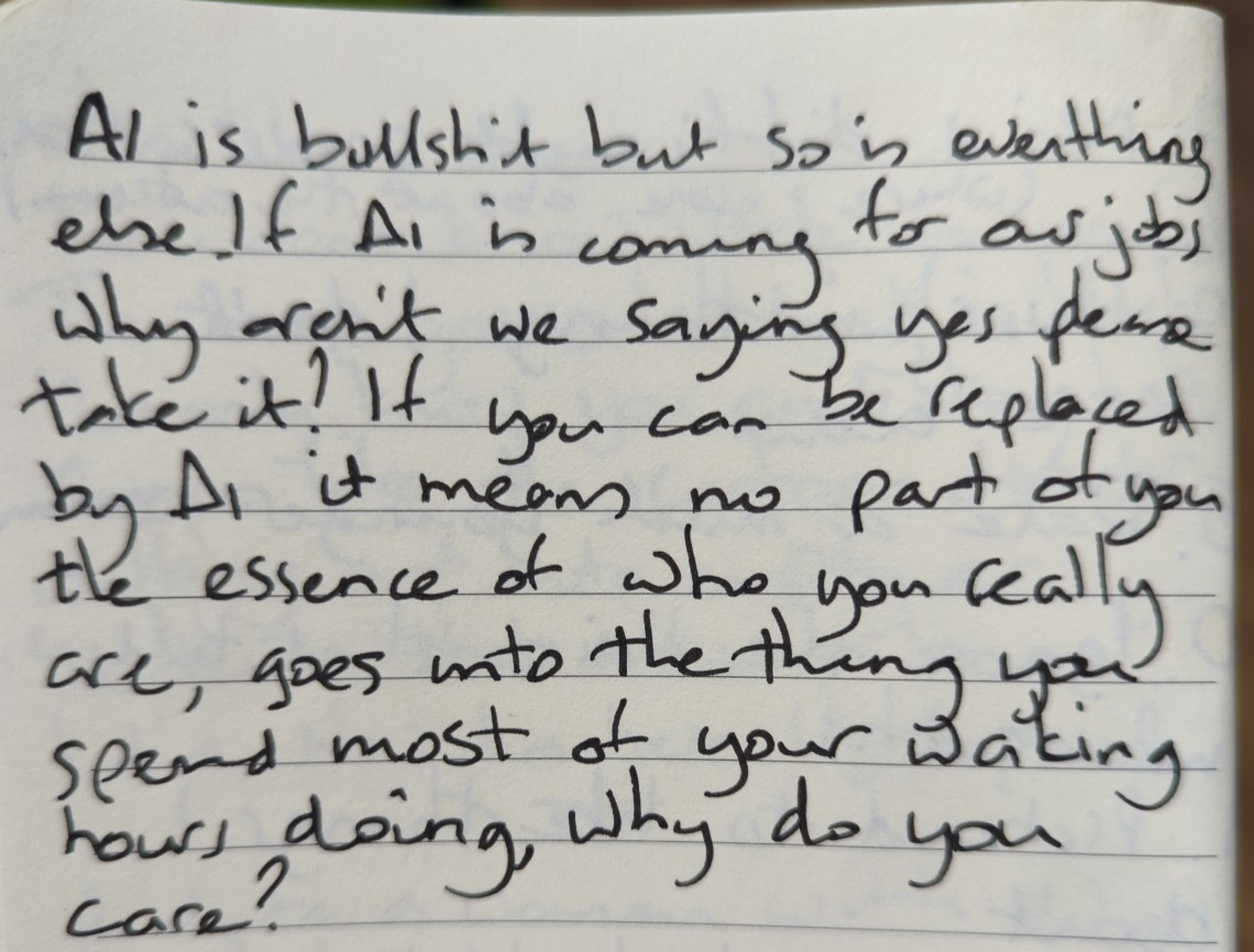 hand-written text in a notebook: "AI is bullshit but so is everything else. If AI is coming for our jobs, why aren't we saying yes please take it! If you can be replaced by AI, it means no part of you - the essence of who you really are - goes into the thing you spend most of your waking hours doing, why do you care?"
